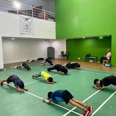 The plank is a fundamental exercise for building a strong core, which is essential for stability and power in every shot. Our players hold the position, building endurance together.