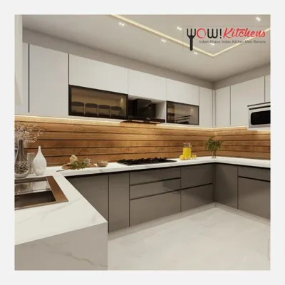 This U-shaped kitchen is the epitome of modern design. It combines matte grey lower cabinets with white upper cabinets and a warm wood-paneled backsplash, all illuminated by subtle under-cabinet lighting.