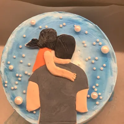 A truly personal cake capturing a special bond. This design features a hand-sculpted fondant topper of a daughter hugging her dad, set against a blue watercolor buttercream background with pearl bubbles.
