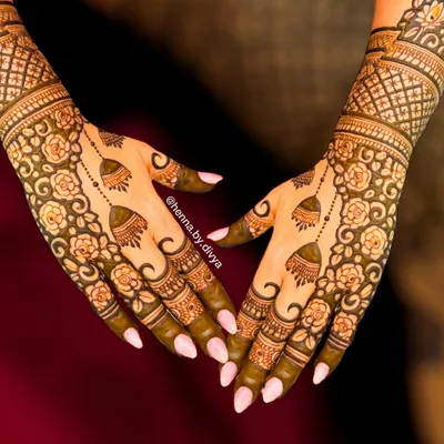 A stunning example of an elegant back-hand design. This piece features a floral vine pattern connected by delicate chains to hanging jhumka (bell) motifs.