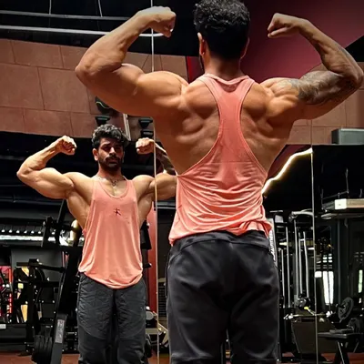 A mirror check showing the results of a dedicated back and shoulder routine. My programs focus on creating that V-taper and impressive rear double biceps pose.