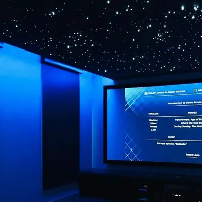 A close-up of a fiber-optic starry night ceiling combined with deep blue ambient cove lighting. This dual lighting system creates a captivating and serene atmosphere, perfect for settling in for a movie.