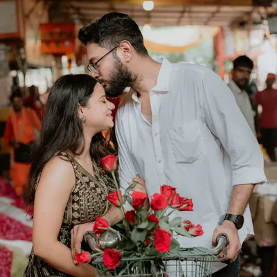 A romantic kiss on the forehead amidst the chaos of the Ghazipur flower market. The roses in the bicycle basket add a classic romantic touch to this unique and candid setting.