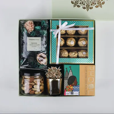 Our 'Royal Blend' hamper is a perfect mix of modern and traditional. It features Ferrero Rocher chocolates, premium mixed nuts, potpourri, and other festive items in an elegant gift box.