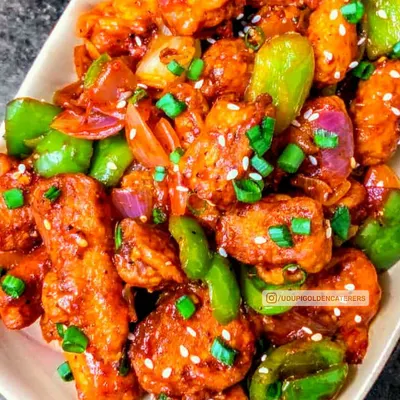 A vibrant platter of Chilli Paneer, featuring soft paneer cubes stir-fried with colorful bell peppers and onions in a spicy and tangy sauce. This dish is a highlight of our live Indo-Chinese counter.