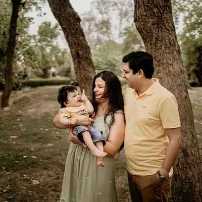 This is what a relaxed family photoshoot looks like. I encourage families to interact naturally, and in this moment, I captured the pure joy of parents laughing with their baby in a lovely park.