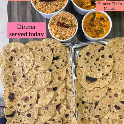 A wholesome dinner of Schezwan Fried Rice, Paneer Tikka Masala, and stacks of soft Ghee Parathas.
