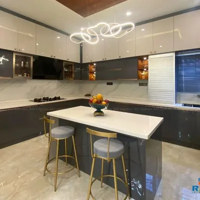 A stunning island kitchen featuring a white quartz countertop, perfect for meal prep and casual dining. The two-tone grey and white cabinets, combined with a modern light fixture, create a sophisticated and contemporary look.
