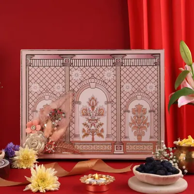 A royal Diwali hamper styled against a rich red backdrop with traditional diyas and flowers to create a truly opulent feel.