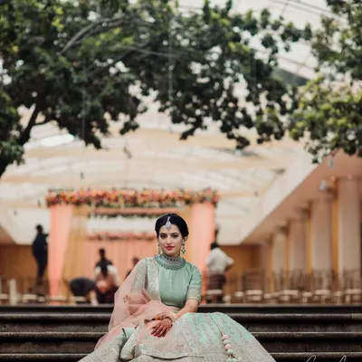 Roshni looking absolutely regal for her engagement. I created a soft, natural makeup look to complement her pastel green lehenga and diamond jewelry, perfect for this elegant outdoor setting.