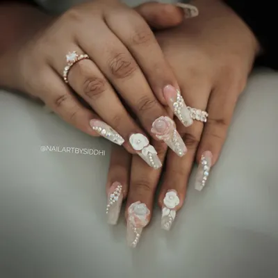 An exceptionally glamorous bridal set featuring long, coffin-shaped nails with 3D sculpted flowers, delicate pearl details, and a cascade of rhinestones. This is for the bride who wants to make a statement.
