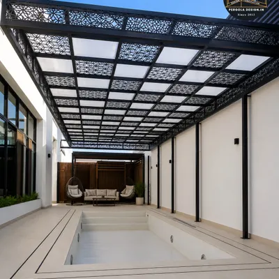 A stunning poolside pergola featuring a roof with custom laser-cut panels. This design provides filtered shade while casting beautiful, intricate patterns on the area below, adding a layer of artistic elegance to the space.