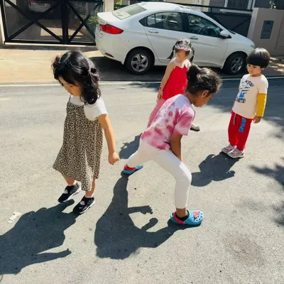 We took learning outside to explore how shadows are formed. Here, children observe their own shadows on the pavement, making a direct connection between their bodies, the sun, and the light.