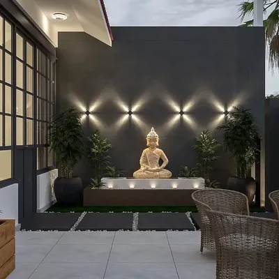 We designed this front verandah as a peaceful retreat from busy city life. A serene Buddha water feature, highlighted by uplighting, creates a calming focal point for the outdoor seating area.