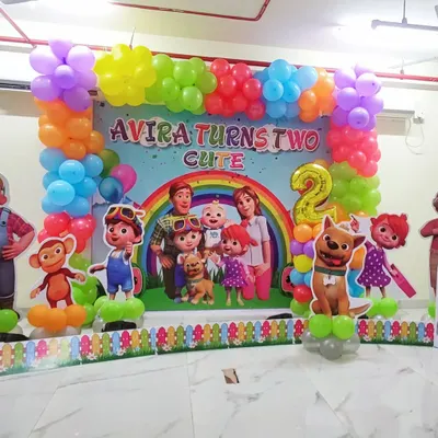 Here is a full-stage Cocomelon theme for a second birthday. The setup includes a large printed backdrop with all the characters, surrounded by a colorful balloon frame and standalone character cutouts for a complete and immersive party look.