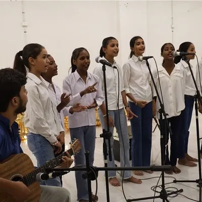 Our Gully Choir girls performing at the SEEkho Showcase. With their instructor on guitar, they sing in harmony, their voices filling the room with confidence and melody.