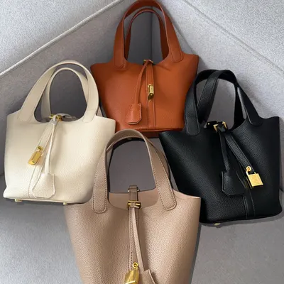 Here are all the available colours for the HerCharm Bucket Bag. From left to right, you can see the off-white, LV brown, black, and taupe options all together.