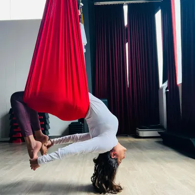Letting go and trusting the process is a core part of the journey. This supported backbend uses the silk hammock to help decompress the spine and open the heart. It’s a pose that feels just as amazing as it looks, and we guide you into it step by step.