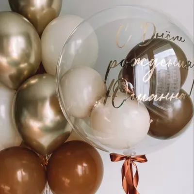 An elegant and sophisticated custom bubble balloon bouquet. This arrangement features a personalized clear bubble balloon filled with smaller balloons, surrounded by a bouquet in a chic palette of brown, beige, and chrome gold.