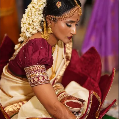 A beautiful South Indian bride during her wedding rituals. We created a classic look with bold, defined eyes, a deep lip color, and a traditional floral hairstyle.