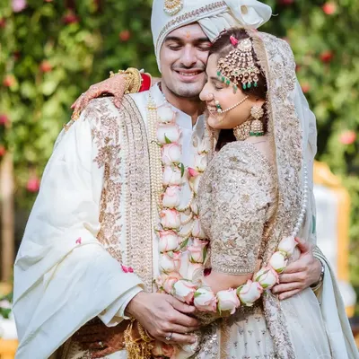 A beautiful, candid moment of the couple hugging after the varmala exchange, their faces filled with pure happiness.