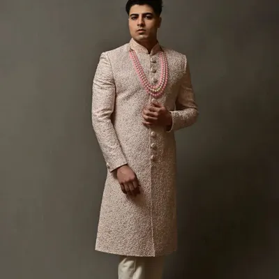 A full-length view of an elegant off-white sherwani with delicate embroidery. This pre-loved piece is perfect for a groom who wants a sophisticated and royal look.