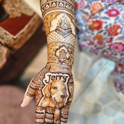 This bridal design tells a complete story. It features a portrait of the family dog 'Jerry' on the palm, a depiction of the wedding fire ceremony (havan kund), and the family temple on the arm.
