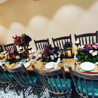 Here is an example of an intimate birthday dinner I styled for a small group. The setup included a long table with rustic wooden chairs, elegant floral centerpieces, and personalized details like the 'Happy Birthday Rhia' sign to make the guest of honor feel special.