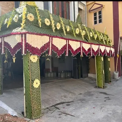 Another example of a traditional housewarming entrance decoration. This arch is constructed from woven green coconut leaves and detailed with red and white flower patterns.