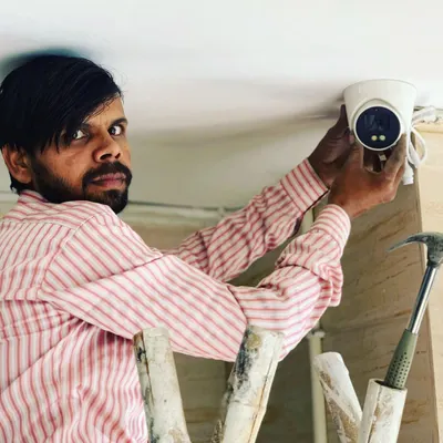 Our technician carefully installs a dome camera on a ceiling. We make sure the placement is perfect for wide coverage inside your shop or office.