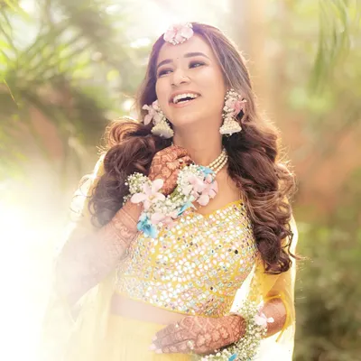 The pure joy of a Haldi ceremony, captured beautifully. We created this pastel floral set with a maang tikka, necklace, and haath phool to match her sunny yellow outfit.