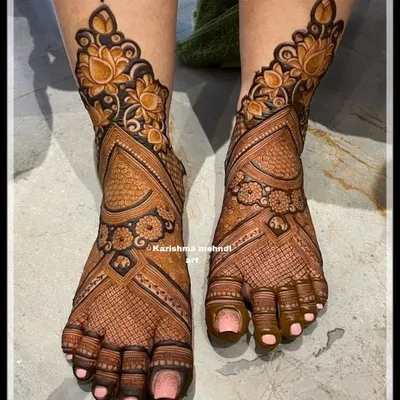 A stunning bridal feet design featuring bold lotus flowers at the ankle. The pattern flows down in a geometric weave, covering the entire foot with intricate detail for a very rich look.