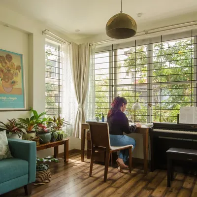 A home office addition designed to maximize its connection to the green outdoors. The large window allows natural light to flood the space, where the desk is positioned to offer a constant view of the garden.