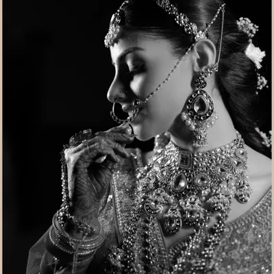 A timeless black and white portrait of the bride. This artistic shot highlights the intricate details of her jewelry and the classic beauty of her profile.