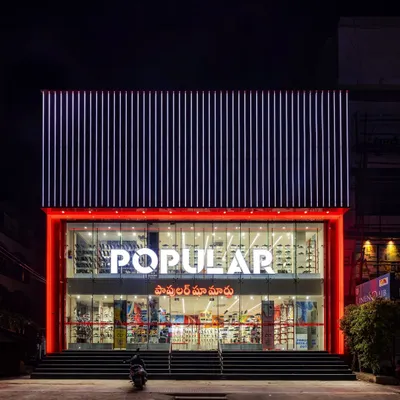 The facade of the Popular Shoe Mart in Tirupati, a project where we used a bold, red-framed glass front and a striking upper section of aluminum composite panels. A strong facade is the first chapter of the brand's story.