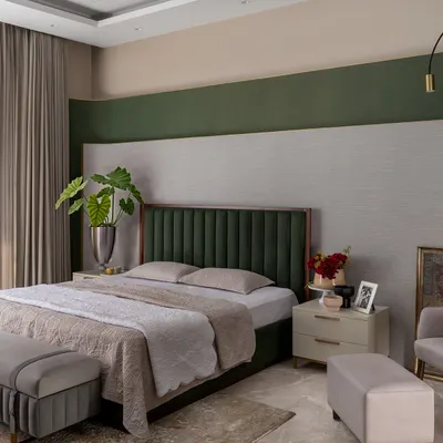 This calming bedroom features a deep green velvet headboard set against a multi-layered, textured wall. We use color with intent, creating a focal point that adds personality and depth without overwhelming the serene atmosphere.