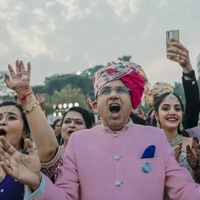 The groom's family cheering with all their heart during the varmala. Capturing the raw emotion and excitement of your family is so important.