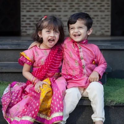 The joy and color of cultural celebrations are incredible to photograph. These siblings, dressed in beautiful traditional wear, share a laugh, creating a perfect, vibrant memory.