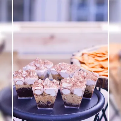 Our Tiramisu Shots are a decadent and elegant dessert option. Layers of coffee-soaked ladyfingers and creamy mascarpone are topped with cocoa powder and marshmallows, served in individual cups.