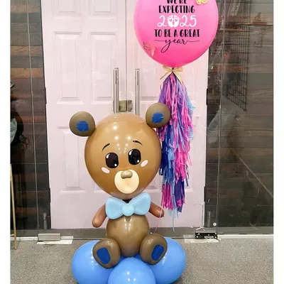 The most adorable way to share your big news! This teddy bear balloon sculpture, holding a personalized announcement balloon, is a sweet and memorable prop for a pregnancy reveal photoshoot.