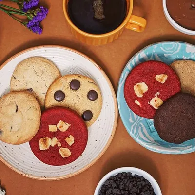 A top-down flat lay of assorted cookies, coffee, and chocolate, creating a warm and inviting scene. This style is effective for cafe menus, baking blogs, and social media content for food brands.