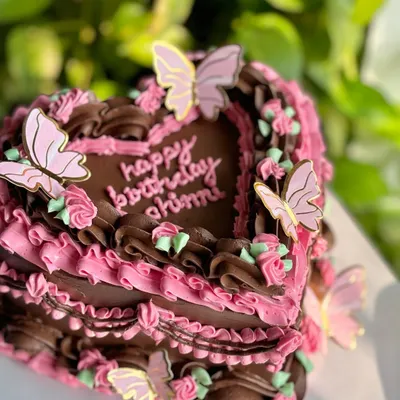 Edible art, but make it luxurious. This vintage heart-shaped cake combines rich chocolate and pink buttercream piping, delicate rosettes, and whimsical butterflies for a truly showstopping birthday centerpiece.