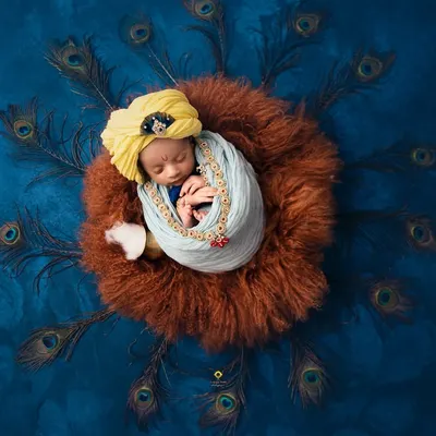 A top-down view of my Little Krishna setup. The circle of peacock feathers creates a stunning frame around the sleeping baby, making for a breathtaking and artistic newborn portrait.