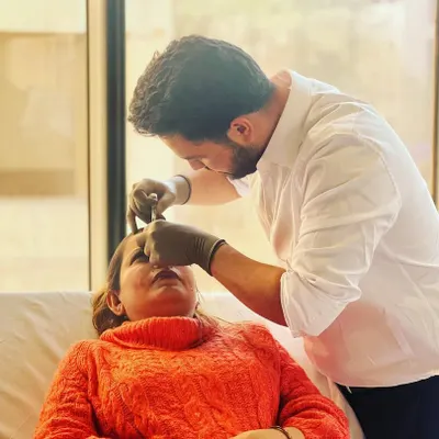 This image captures a key moment during an injectable hydration treatment. I am carefully administering a hydro-booster into the upper layers of the skin to address static lines and improve overall skin texture.