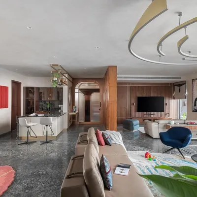 An overview of the open-floor plan in the Quintessence apartment, showing the seamless transition between the living, dining, and kitchen areas. Though physically connected, each space is given its own identity through distinct materials, lighting, and furniture arrangements, creating a harmonious and functional home.