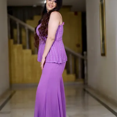 A full-length portrait of a guest in a striking purple outfit, captured in a well-lit hallway. I use the venue's spaces to create elegant individual portraits.