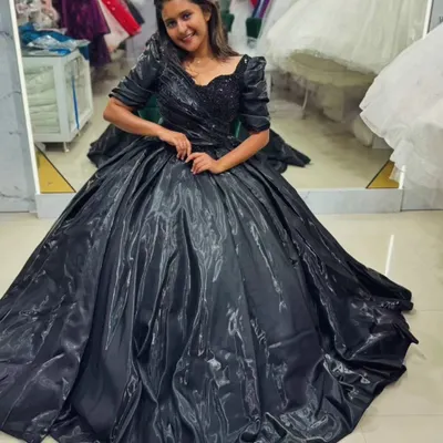 Embrace your dark fairytale moment. This stunning black ball gown features a voluminous, shimmering satin skirt and a delicately beaded bodice, creating a look of pure drama and elegance.