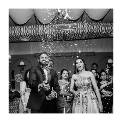 A legendary celebration begins! This black and white shot of the champagne pop is full of energy and excitement, perfectly kicking off the after-party.