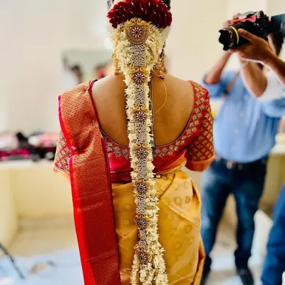 A royal braid with an awesome pearl and peacock embellishment. This is a grand and intricate hairstyle, perfect for a bride who wants to make a statement.