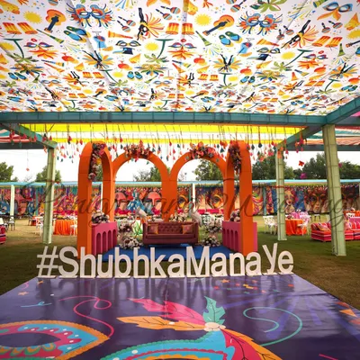 A full view of our fun Carnival-themed Mehendi. The custom printed ceiling and dance floor, colorful arches, and playful hashtag sign create a vibrant and energetic atmosphere.